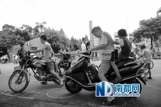 <p>因校車座位不夠，洪梅第二小學(xué)今年的新莞人新生不能坐校車，許多家長(zhǎng)只能騎車接送孩子。南都記者劉在富攝<br /><br /></p>