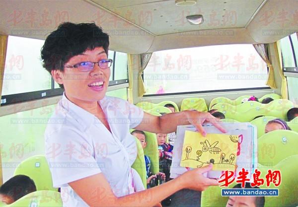 校車隨車照管員劉芳展示她收到的教師節(jié)禮物瑯琊臺小學的學生們親手畫的畫。